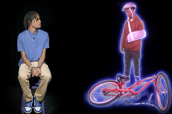 boy sitting looking at another boy who who is injured and his bike is broken