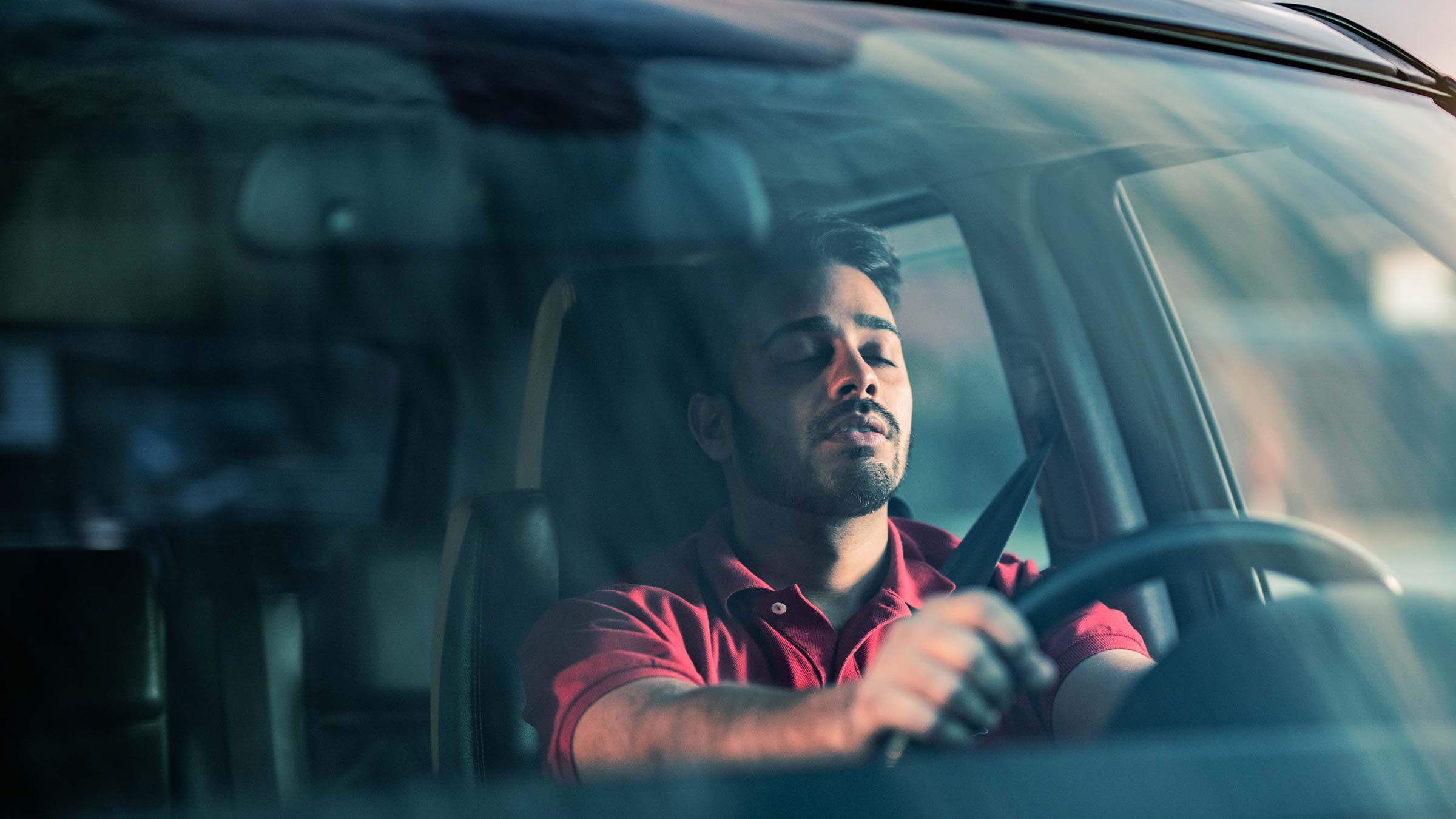 man falling asleep at the wheel of a car