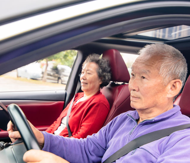 asian couple driving in a car