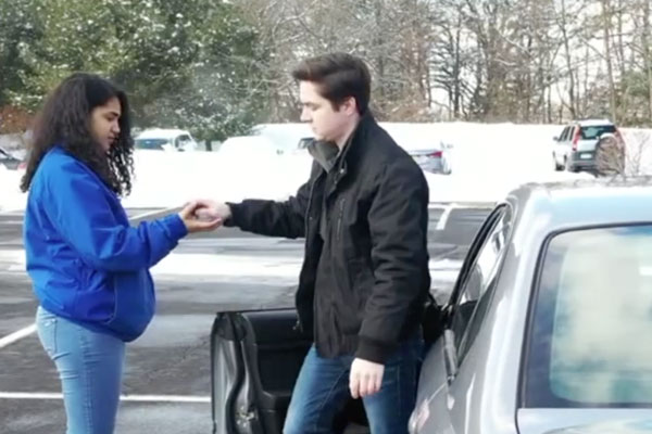 a guy getting out of a car and handing over the keys to a female friend