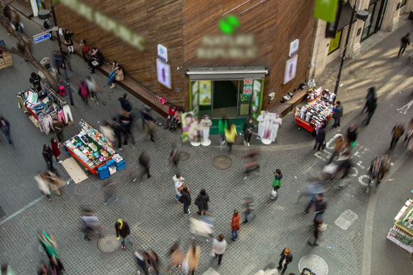 a busy street corner with lots of people seen from above